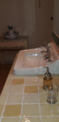 a white sink in a bathroom with a counter at La Maison Des Autres, piscine chauffée, chambres d'hôtes proches Uzès, Nîmes, Pont du Gard in Saint-Géniès-de-Malgoirès