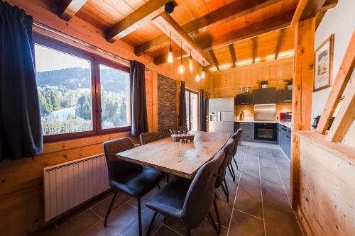une salle à manger avec une table et des chaises en bois dans l'établissement Close to the village - Chalet 4 Bedrooms, Mont-Blanc View, à Megève