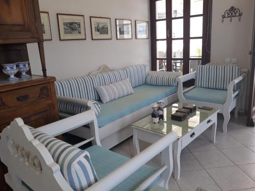 a living room with a blue and white couch and chairs at Eftychias residence in Masouri