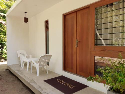 a porch with a table and chairs next to a door at The Loft in Midigama