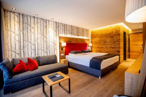 een hotelkamer met een bed en een bank bij Chalet Ifen am Hochgrat in Oberstaufen