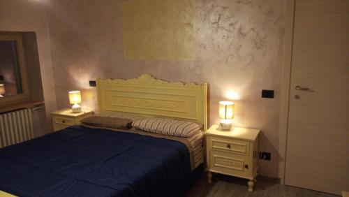 a bedroom with a blue bed and two night stands at Ca' Nova in Roccaforte Mondovì