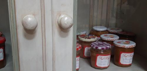 a shelf with jars of jam in a closet at La Maison Des Autres, piscine chauffée, chambres d'hôtes proches Uzès, Nîmes, Pont du Gard in Saint-Géniès-de-Malgoirès