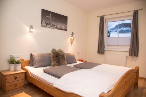 sypialnia z dużym drewnianym łóżkiem i oknem w obiekcie Apartment Erler w mieście Hippach