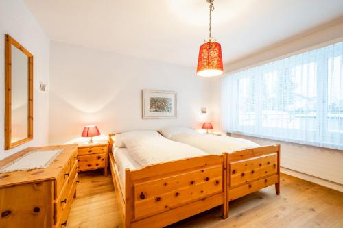 Un dormitorio con una cama grande y una ventana en Via Sulten 12, en Flims