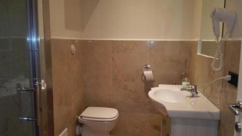 a bathroom with a toilet and a sink and a phone at Chiossone Suites in Genoa