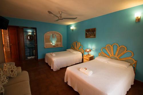 a hotel room with two beds and a couch at Hotel Francis Arlene Adults Only in Isla Mujeres