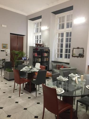 a living room with a glass table and chairs at Chiossone Suites in Genoa