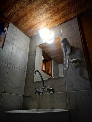 a bathroom with a sink and a light on the wall at Guest House Zlatniyat Telets in Koprivshtitsa