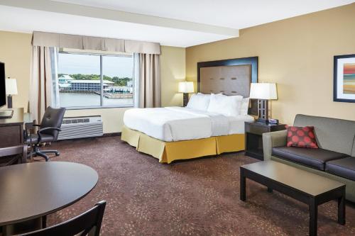 a hotel room with a bed and a living room at Holiday Inn Express & Suites Sandusky, an IHG Hotel in Sandusky