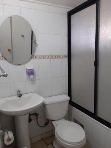 y baño con aseo, lavabo y espejo. en Cabañas Don Foncho, en Castro