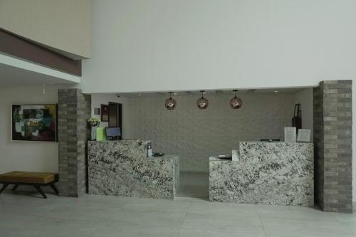 a lobby with three marble tables and lights on the wall at Best Western PLUS Monterrey Colón in Monterrey