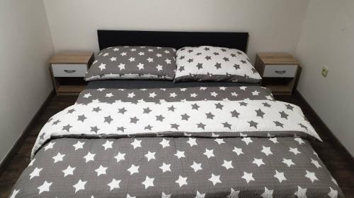 a bed with a black and white comforter and two pillows at Ubytování BOBULKA Bulhary in Bulhary