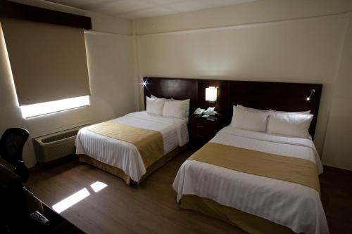 a hotel room with two beds and a window at Best Western Centro Monterrey in Monterrey