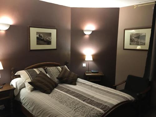 - une chambre avec un lit et deux lumières sur le mur dans l'établissement AU PIED DU VERCORS TOUT EST PERMIS, à La Rivière