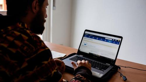 a man sitting at a table with a laptop computer at The Homestay - Arezzo in Arezzo