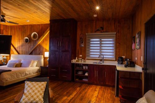 a bedroom with a bed and a kitchen with a sink at Lucero Golf and Country Club Tree Houses in Boquete