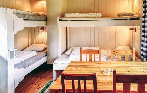 einen Esstisch und Stühle in einem Zimmer mit Etagenbetten in der Unterkunft Awesome Home In Sysslebck With Kitchen in Sysslebäck