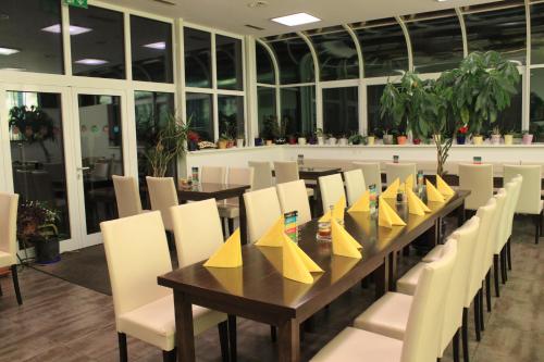 ein Esszimmer mit einem Tisch und Stühlen mit gelben Servietten in der Unterkunft Pension & Restaurant TsingDao in Hörbranz