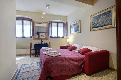 a bedroom with a bed with a red blanket and a table at Neri 0 in Florence