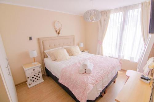 a bedroom with a bed with two stuffed animals on it at Depto primera línea de playa para 5 personas in Villarrica
