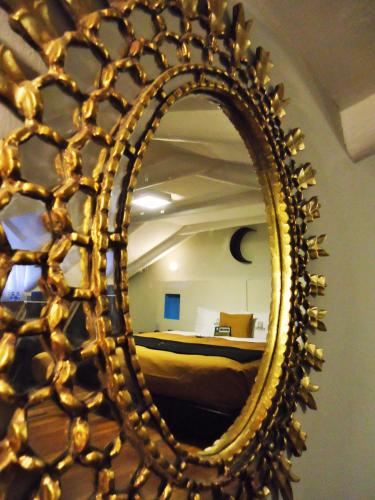 a gold mirror in a room with a bed at Hotel San Francisco Plaza in Cusco