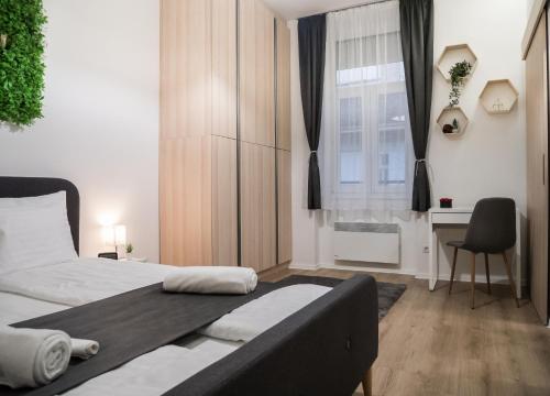 1 dormitorio con cama, escritorio y ventana en Stunning Studio Apartment, en Budapest