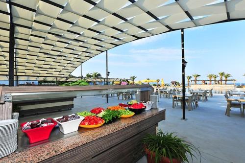 a table with plates of food on a patio at Afytos Akcay Tatil Koyu in Balıkesir
