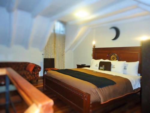 a bedroom with a large bed and a couch at Hotel San Francisco Plaza in Cusco