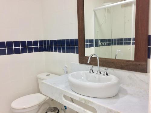 uma casa de banho branca com um lavatório e um WC em Pousada Costão do Sol em Angra dos Reis