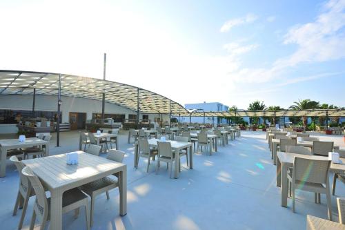 a row of tables and chairs on a patio at Afytos Akcay Tatil Koyu in Balıkesir