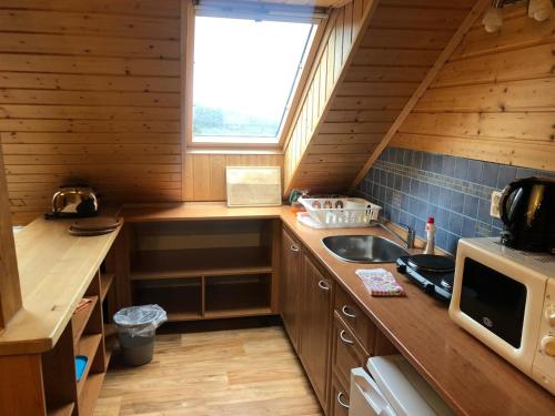 a small kitchen with a sink and a microwave at Kubovka 63 in Kubova Huť
