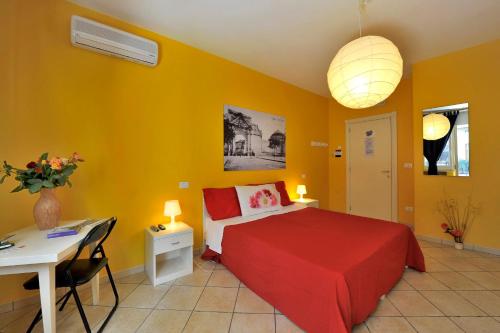 Schlafzimmer mit einem roten Bett und einem Schreibtisch in der Unterkunft Barocco.Oberdan in Lecce