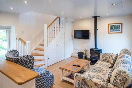 a living room with a couch and a table at Ardnavaha House - Poolside Cottages in Clonakilty