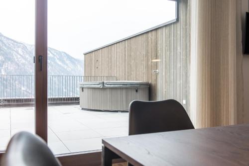 a conference room with a table and a view of a balcony at Mountain Residence Montana in Santa Maddalena in Casies