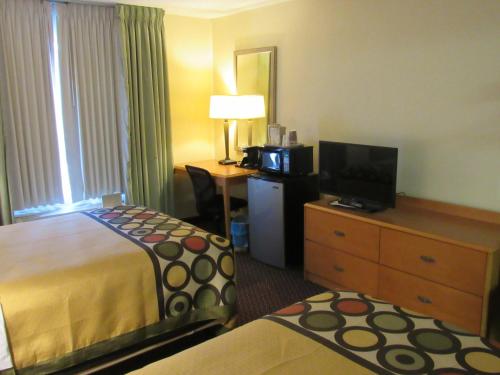 a hotel room with a bed and a television at Super 8 by Wyndham New Cumberland in New Cumberland