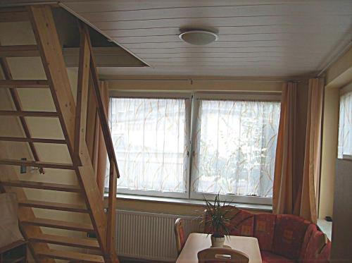 a room with a staircase and a table and a window at Järgen Ferienappartements in Koblenz