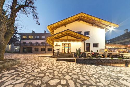 ein großes weißes Gebäude mit einer Terrasse in einem Innenhof in der Unterkunft Edelweiss Central Hotel in Bansko