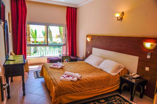 A bed or beds in a room at Hotel Saghro