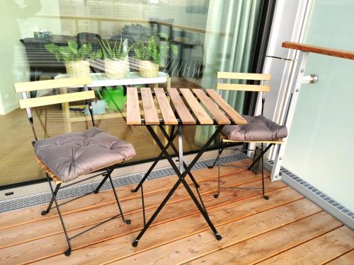 einen Holztisch und zwei Stühle auf dem Balkon in der Unterkunft Apartment am Belvedere Vienna in Wien