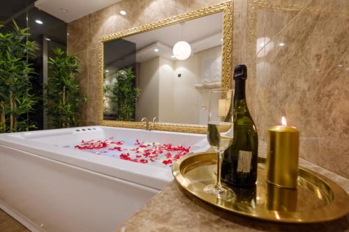a bathroom with a tub and a bottle of champagne at Central Business Apartments Jacuzzi in Belgrade