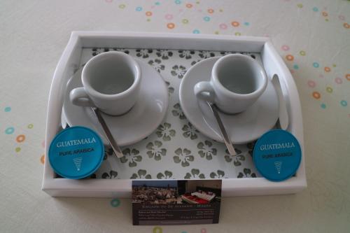 two cups and a plate in a box with a book at Escape to St Julians in St Julian's
