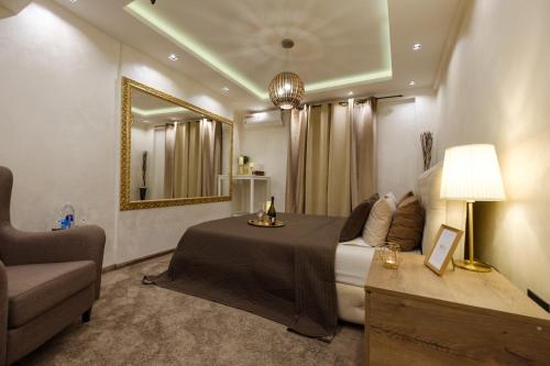 a bedroom with a bed and a couch and a mirror at Central Business Apartments Jacuzzi in Belgrade