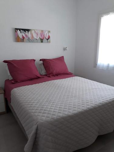 a bedroom with a large bed with pink pillows at Villa Ligia Beach in Koundouros