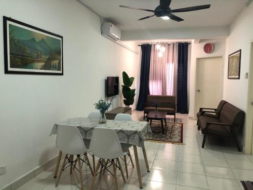 een woonkamer met een eettafel en stoelen bij Medina Homestay, Wakaf Che Yeh in Kota Bharu
