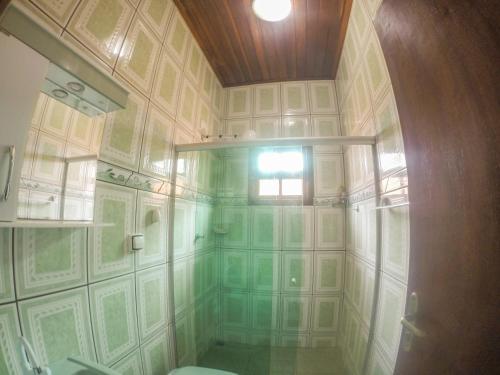 a bathroom with a green and white tiled wall at Solar dos Borges in Carrancas