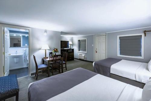 a hotel room with two beds and a desk at Mt. Madison Inn & Suites in Gorham