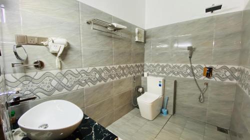 La salle de bains est pourvue de toilettes, d'un lavabo et d'une douche. dans l'établissement Ziegler Cottage, à Negombo