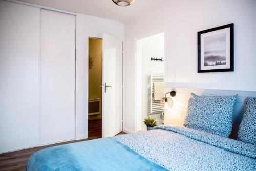 a bedroom with a blue bed in a white room at Chic & Cosy Appartement avec Terrasse, Parking Privatif in Saint-Grégoire