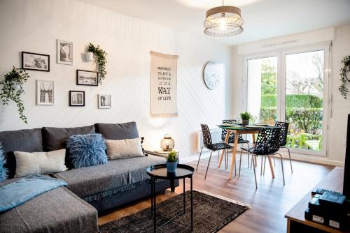 a living room with a couch and a table at Chic & Cosy Appartement avec Terrasse, Parking Privatif in Saint-Grégoire